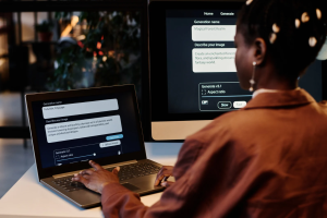 Small business owner responding to messages on her laptop